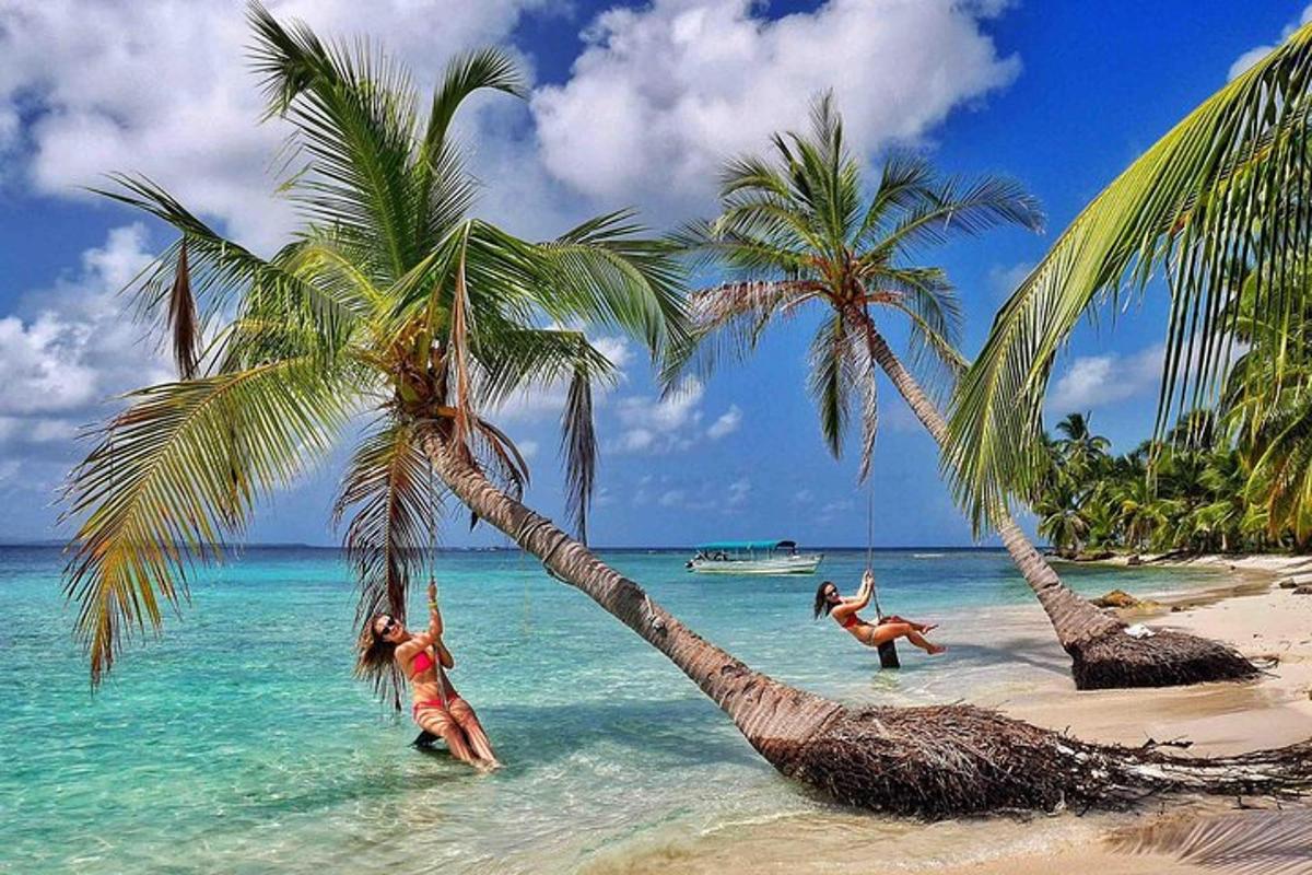 zwei Menschen spielen im Wasser mit Palmen an einem Strand