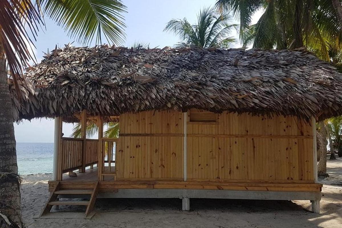 eine Hütte mit Strohdach am Strand