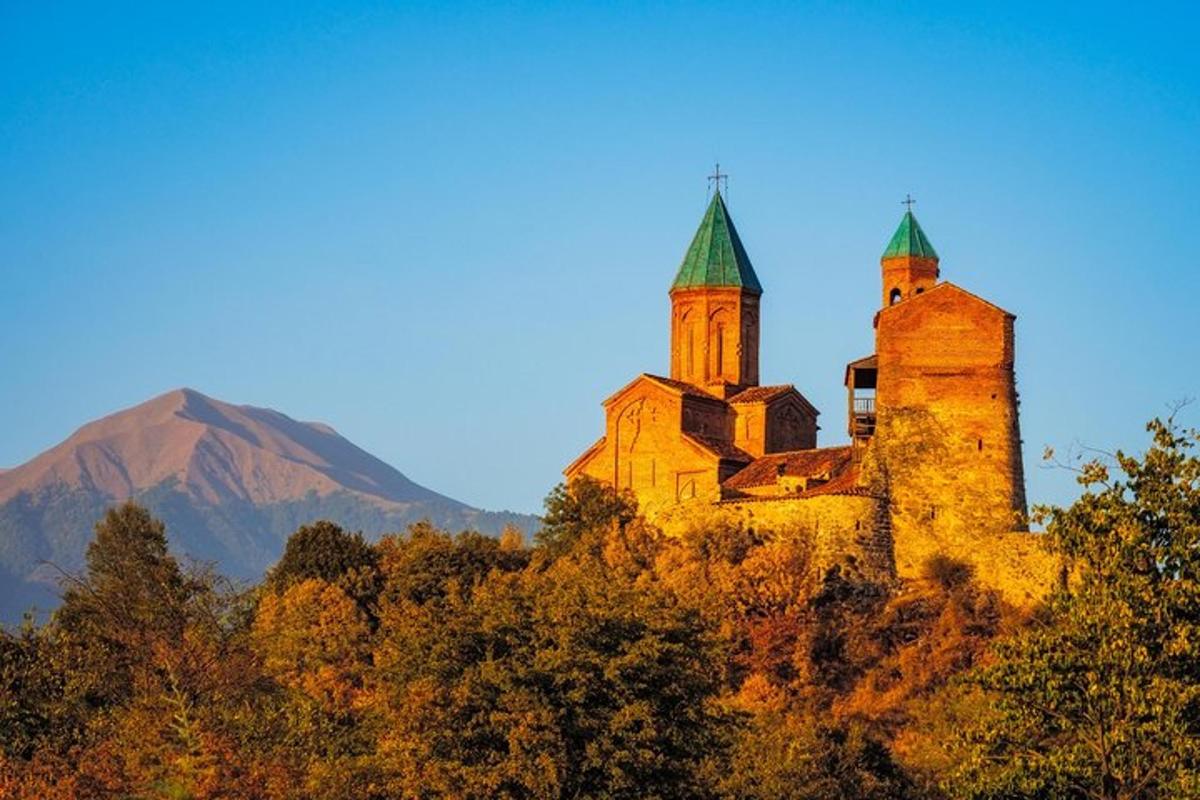 una vecchia chiesa su una collina con una montagna sullo sfondo