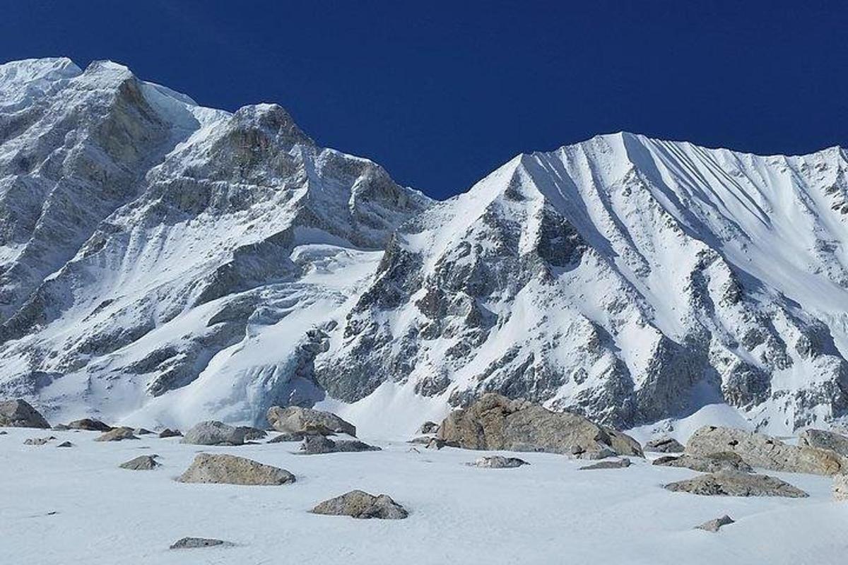 gunung yang dilitupi salji dengan batu di hadapannya