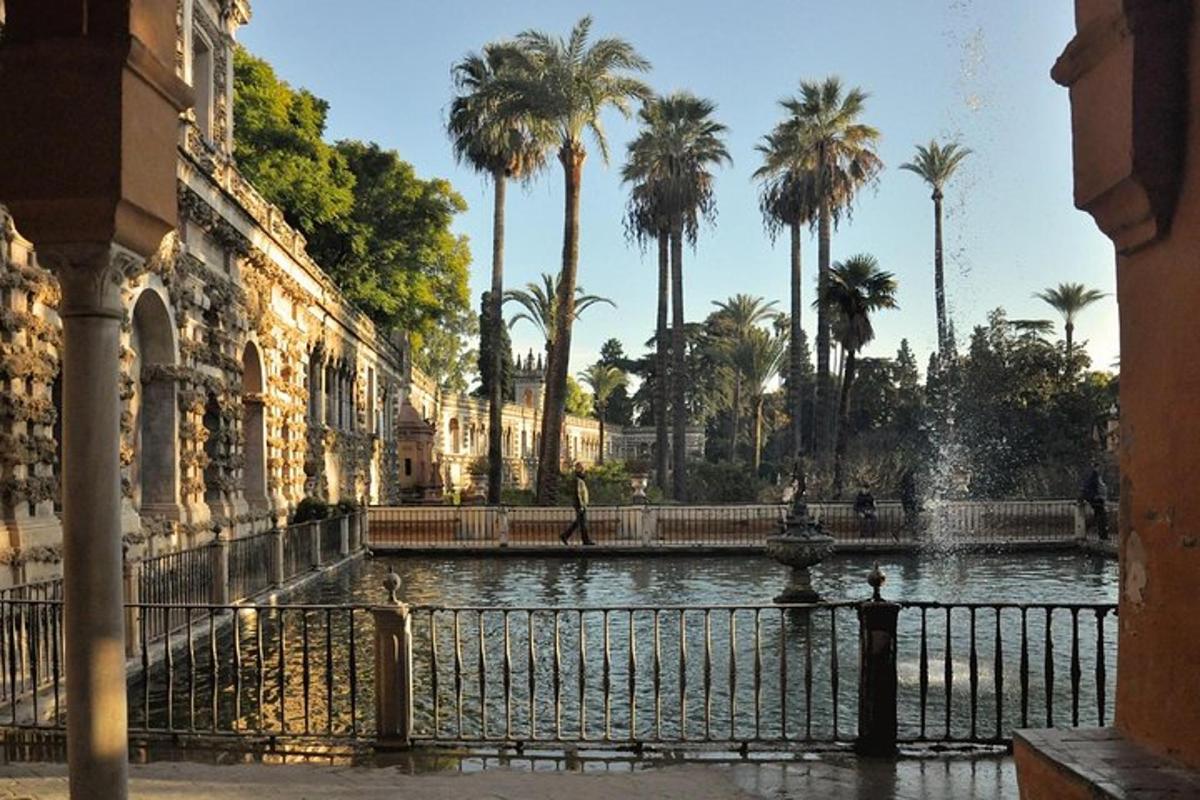 a pond with palm trees in front of a building