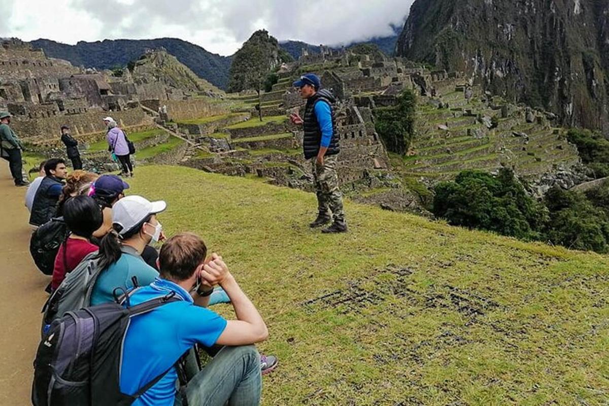 Un grupo de personas mirando a un hombre parado en una montaña.