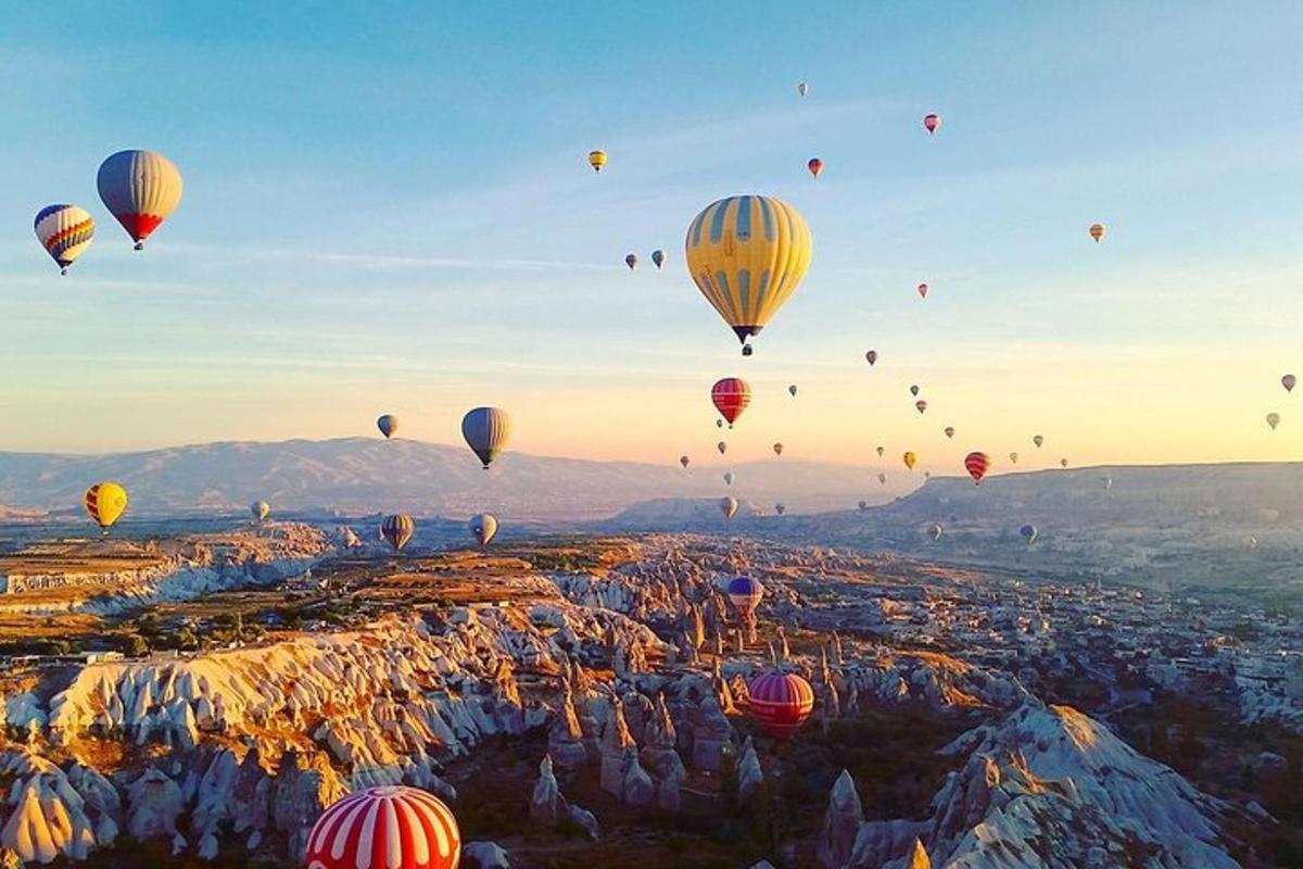 egy csoport hőlégballon repül egy város felett