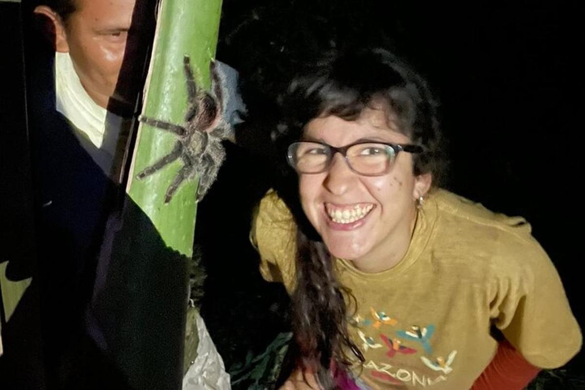 Una mujer con gafas de pie junto a una tabla de surf