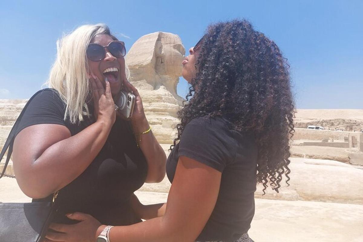two women are standing in front of a monument