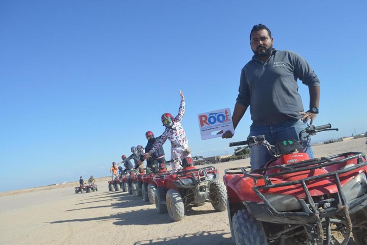 sekelompok orang berdiri di atas ATV di padang pasir