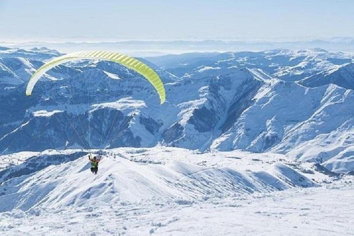 en person som flyr fallskjerm på toppen av et fjell
