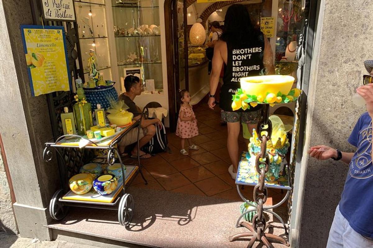 Una mujer entrando a una tienda con una niña delante.