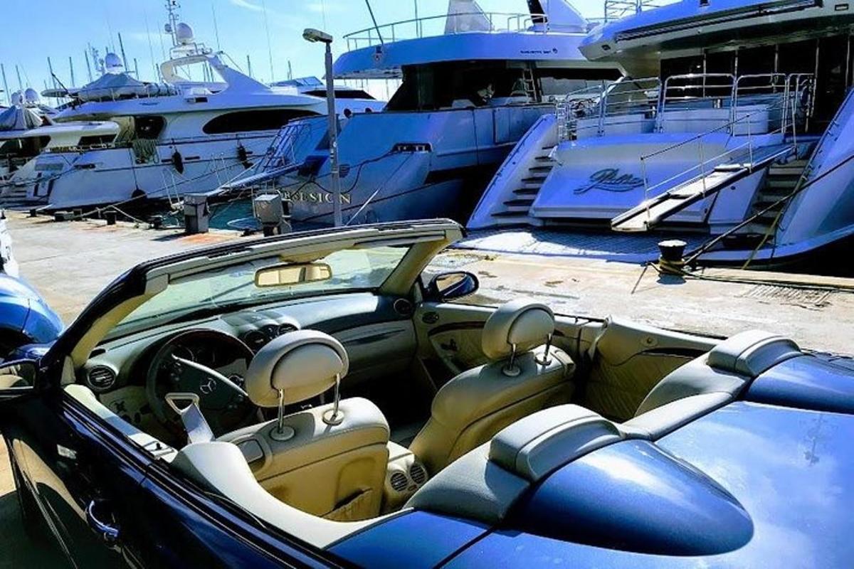 ein in einem Yachthafen neben Booten geparktes Auto