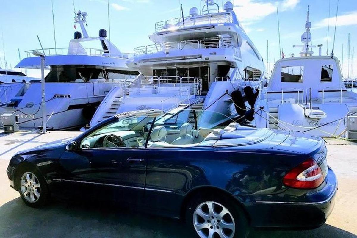 ein blaues Auto, das vor einem Boot geparkt ist