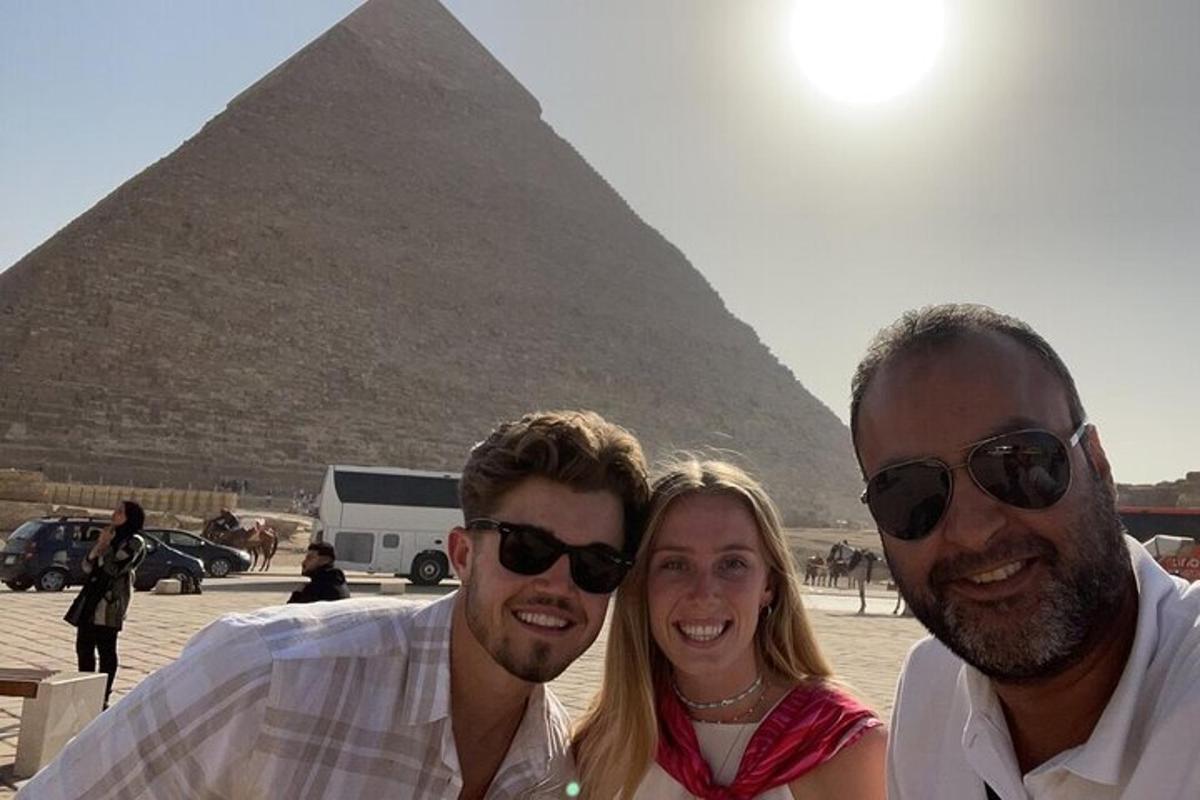 tre persone in piedi davanti alla piramide