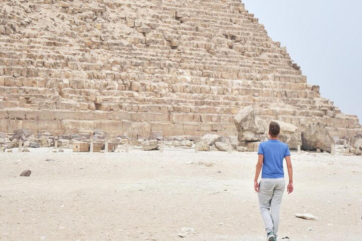 un uomo in piedi davanti a una piramide