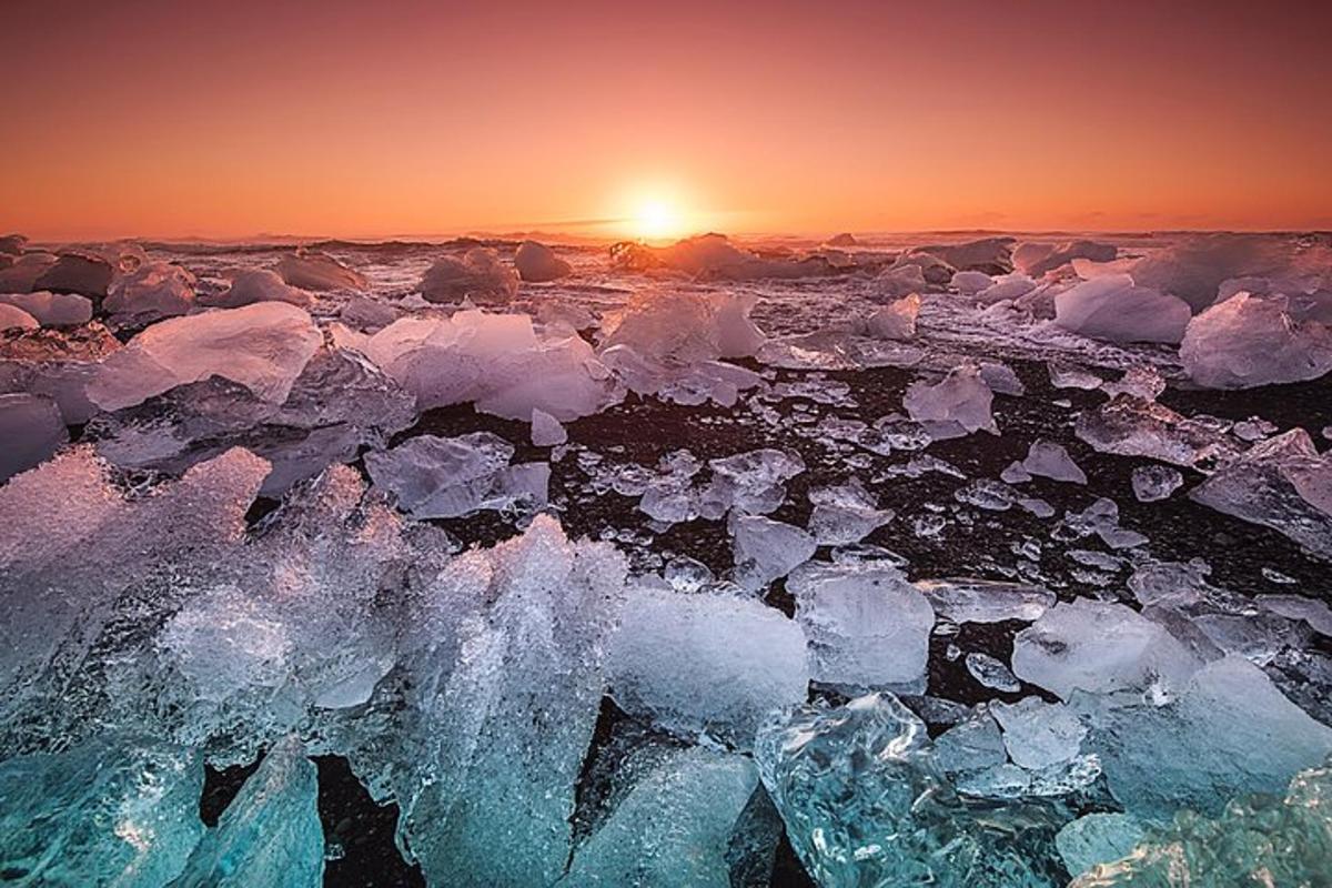 an ice field with the sun setting in the background