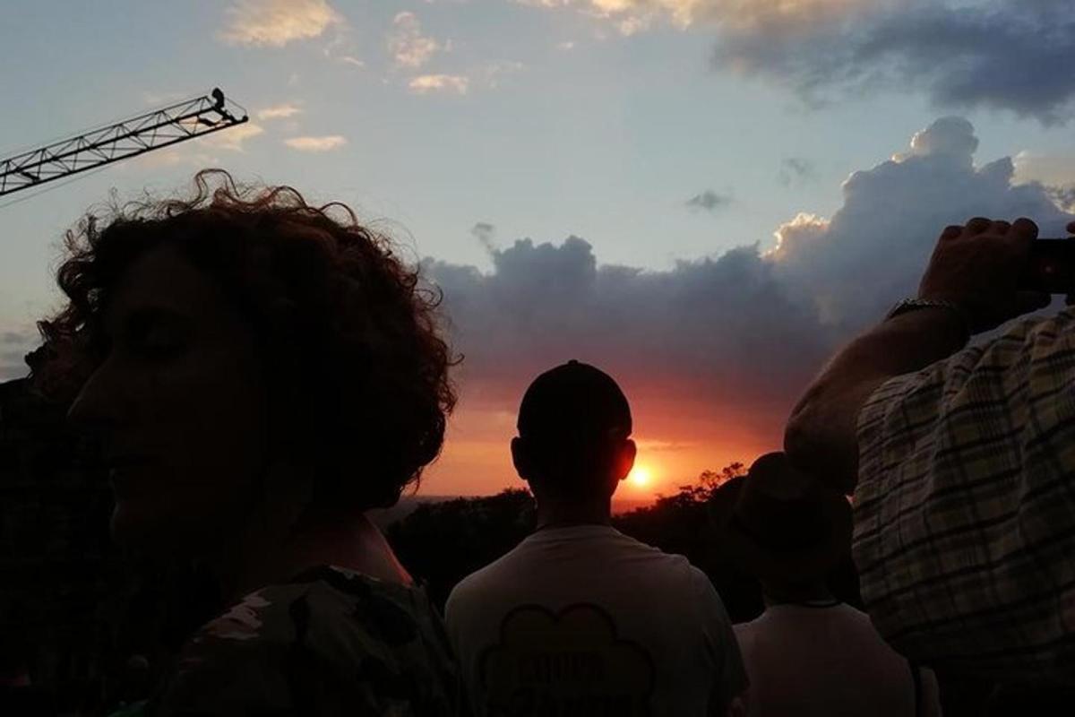 Un grupo de personas tomando fotografías del atardecer.
