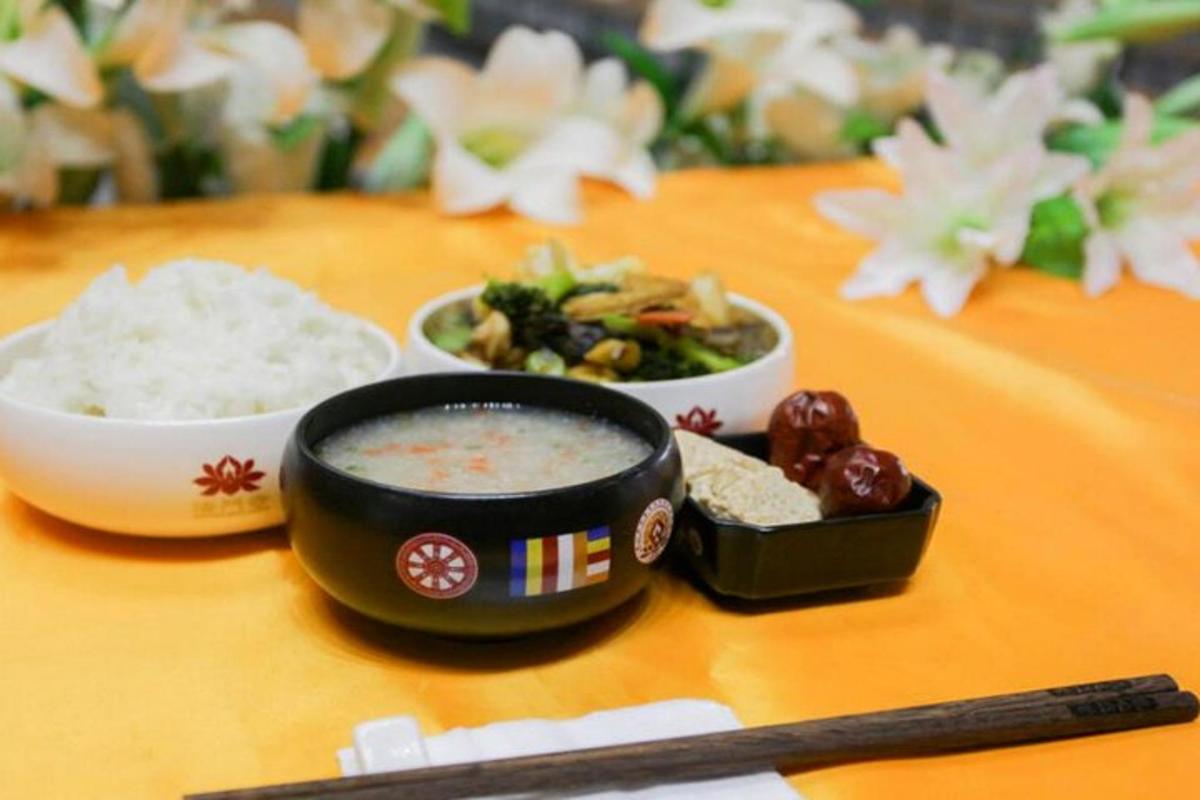 a table with a bowl of soup and bowls of rice