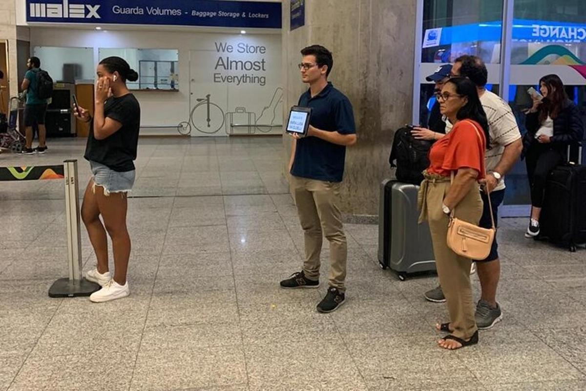 un grup de persones esperant el seu equipatge a l'aeroport