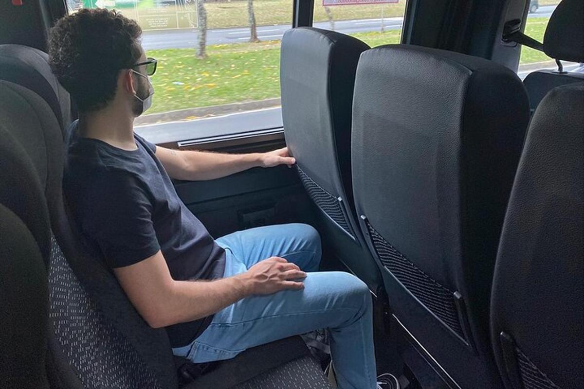 muž sedící na zadním sedadle autobusu