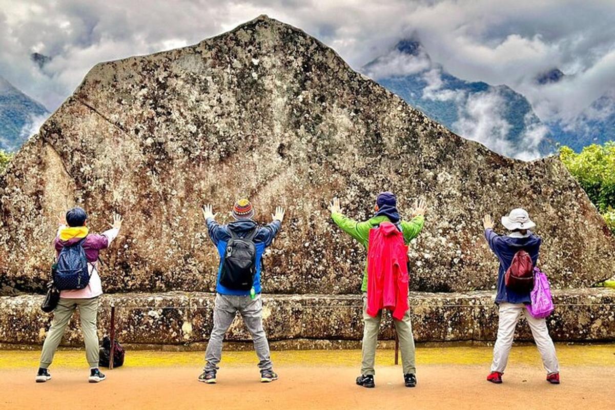 eine Gruppe von Menschen steht vor einem großen Felsen