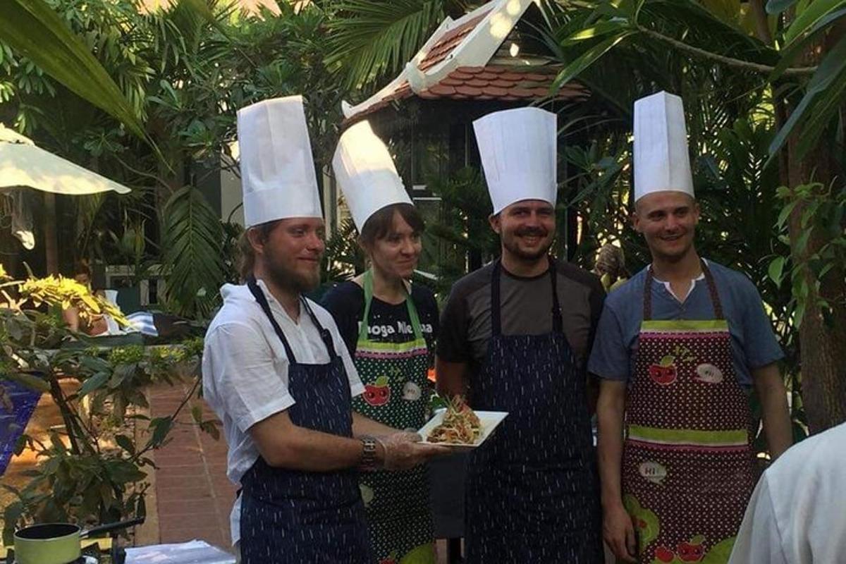 a group of people wearing chefs hats holding food