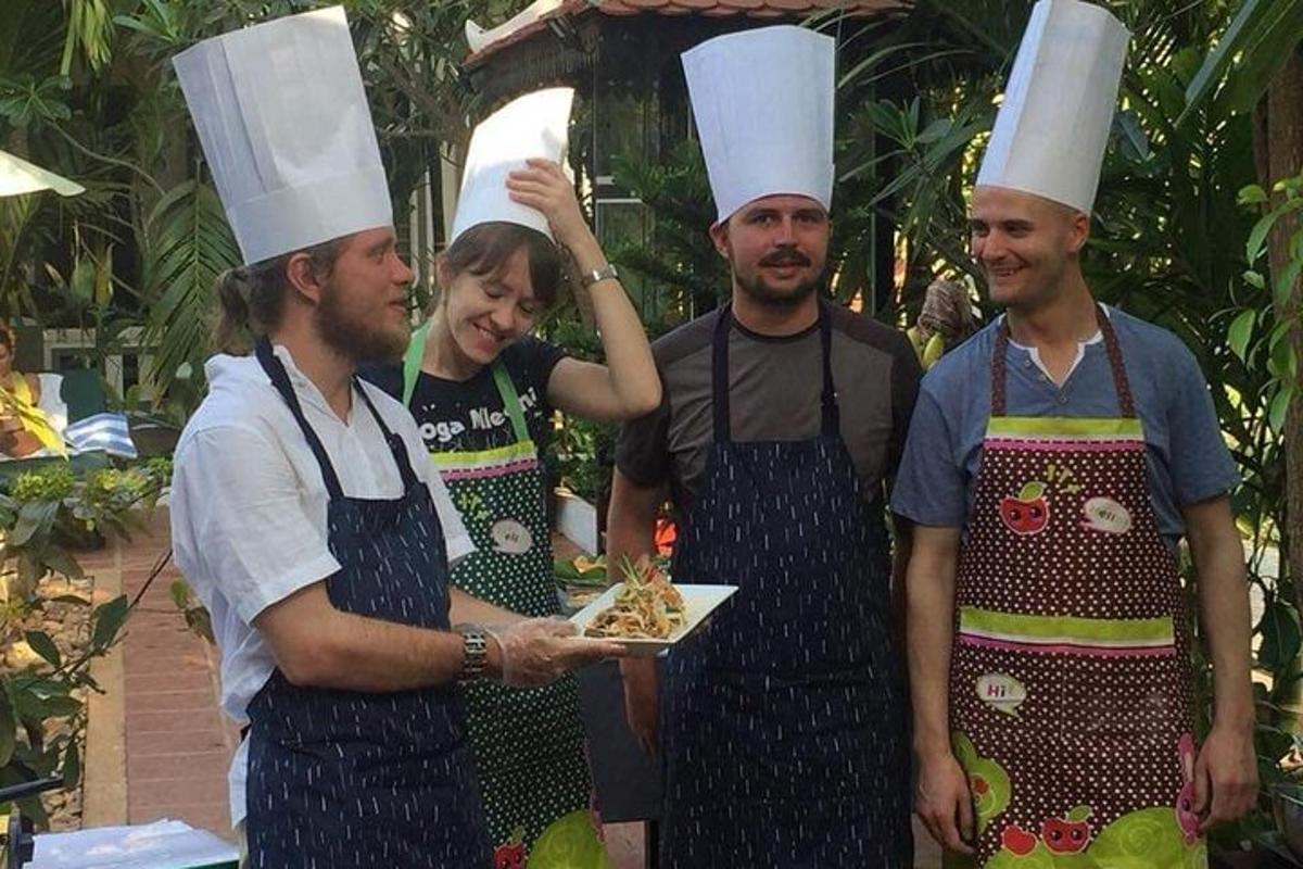 a group of people wearing chef hats holding a plate of food
