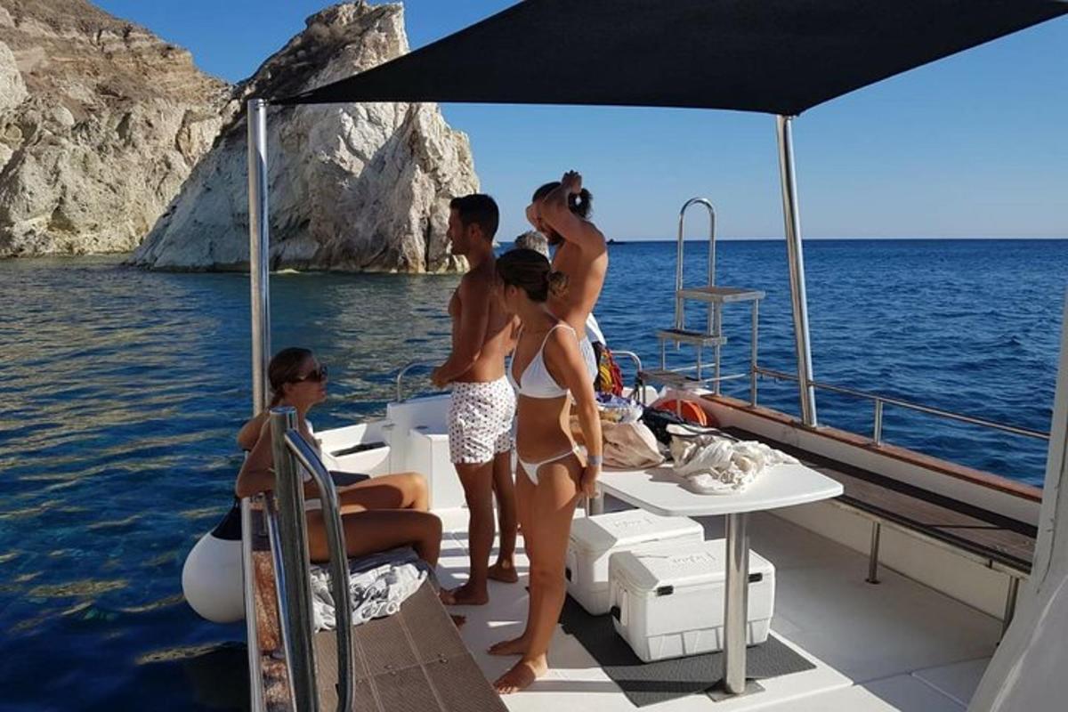 un gruppo di persone in piedi su una barca in acqua