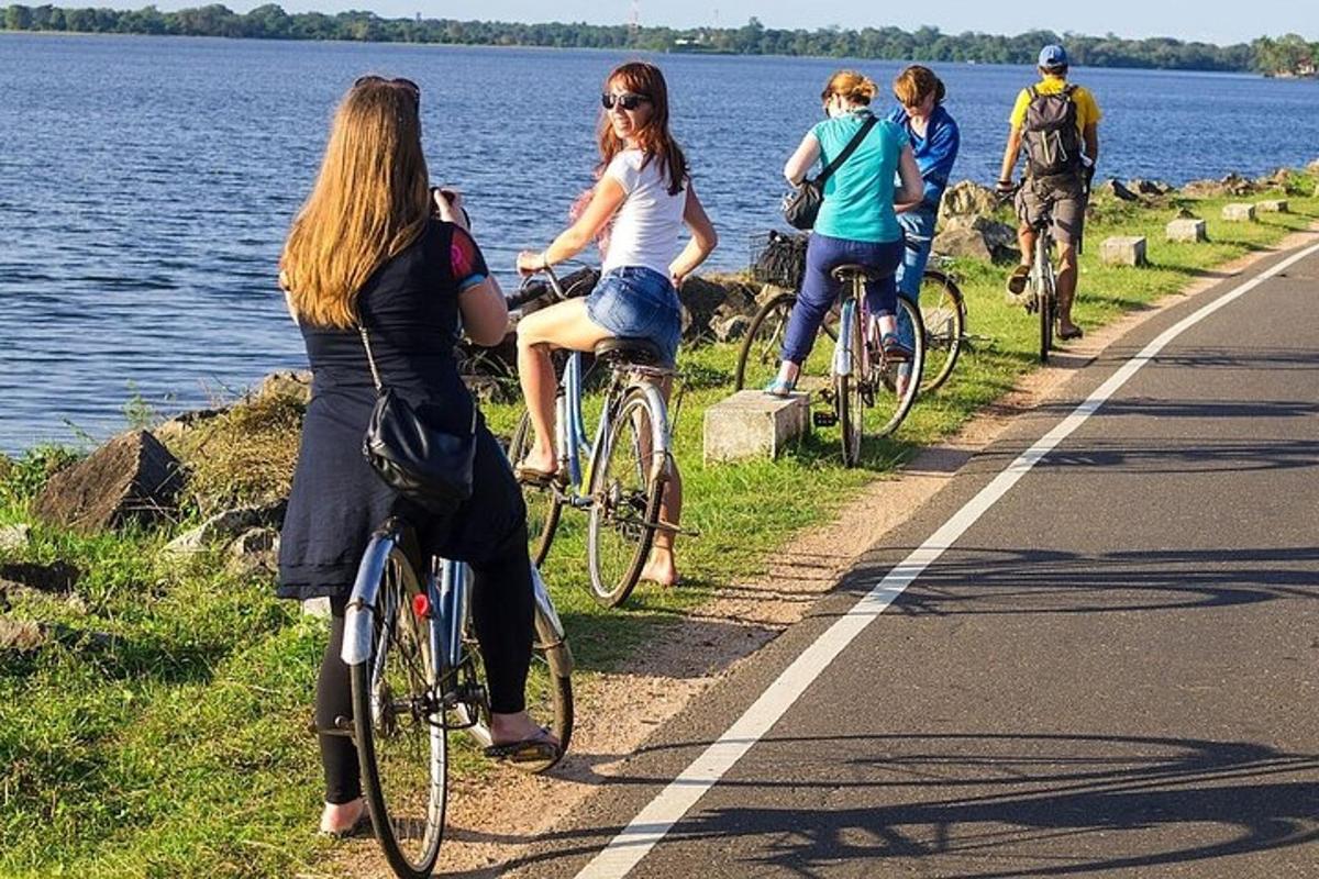 水辺の道路に沿って自転車に乗る人々のグループ