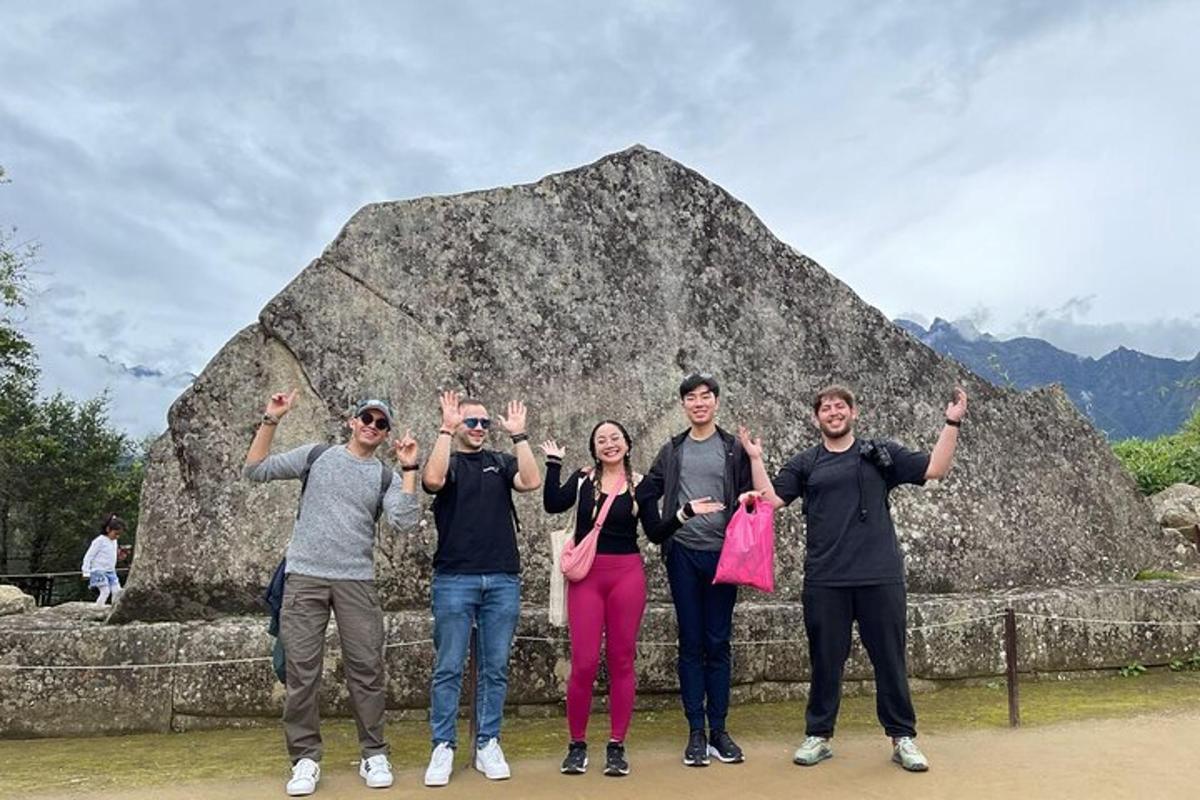 Un grupo de personas de pie frente a una roca