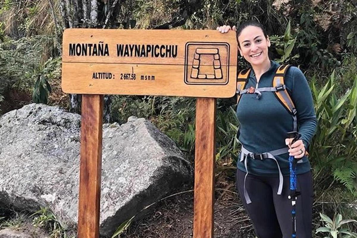 žena stojí vedle cedule