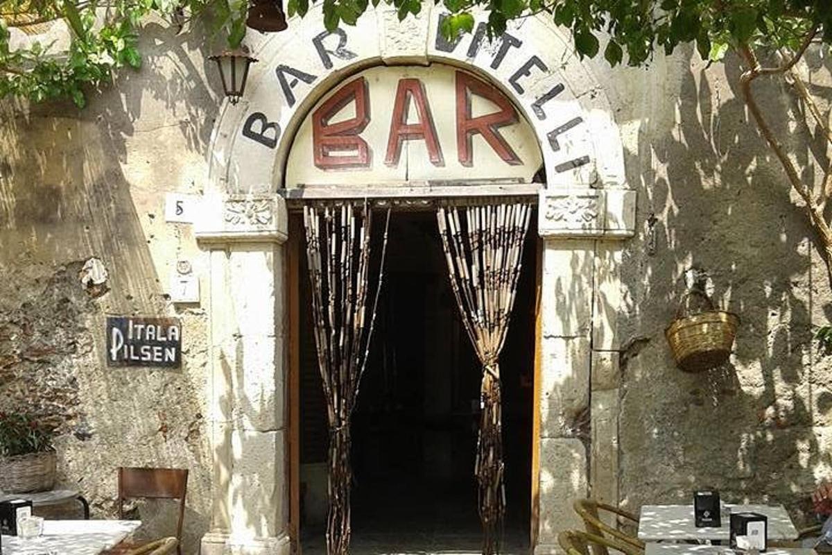 un ingresso di un edificio con un cartello da bar sopra