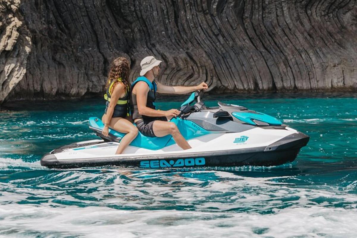 dues persones muntant una moto aquàtica a l'aigua
