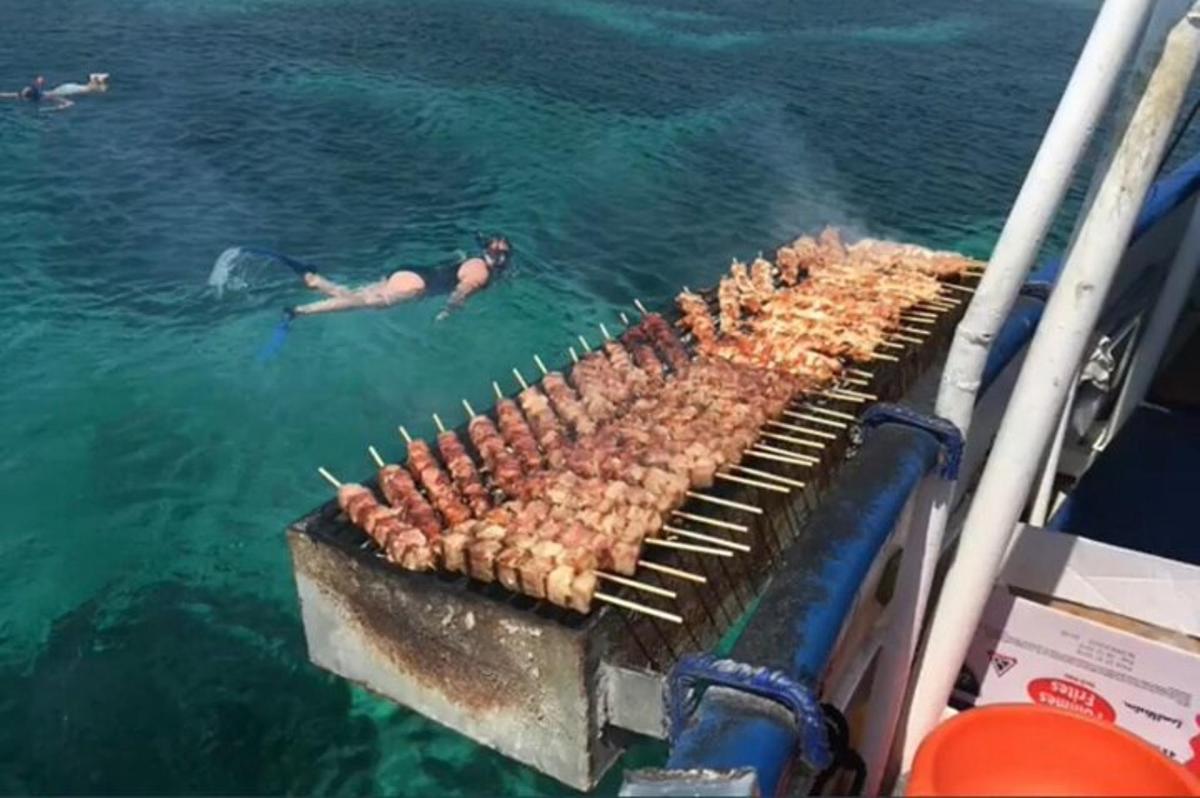 a man in the water next to a grill in the water
