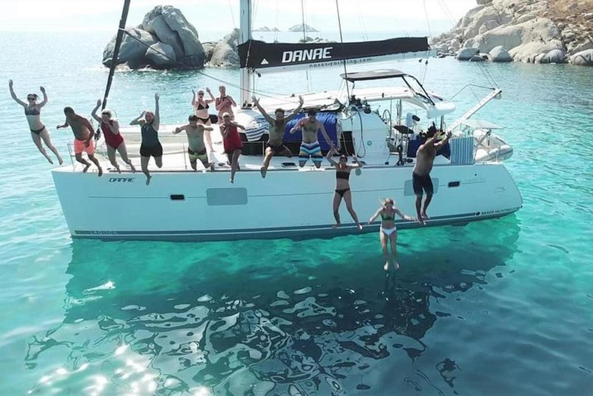 a group of people jumping off a boat in the water