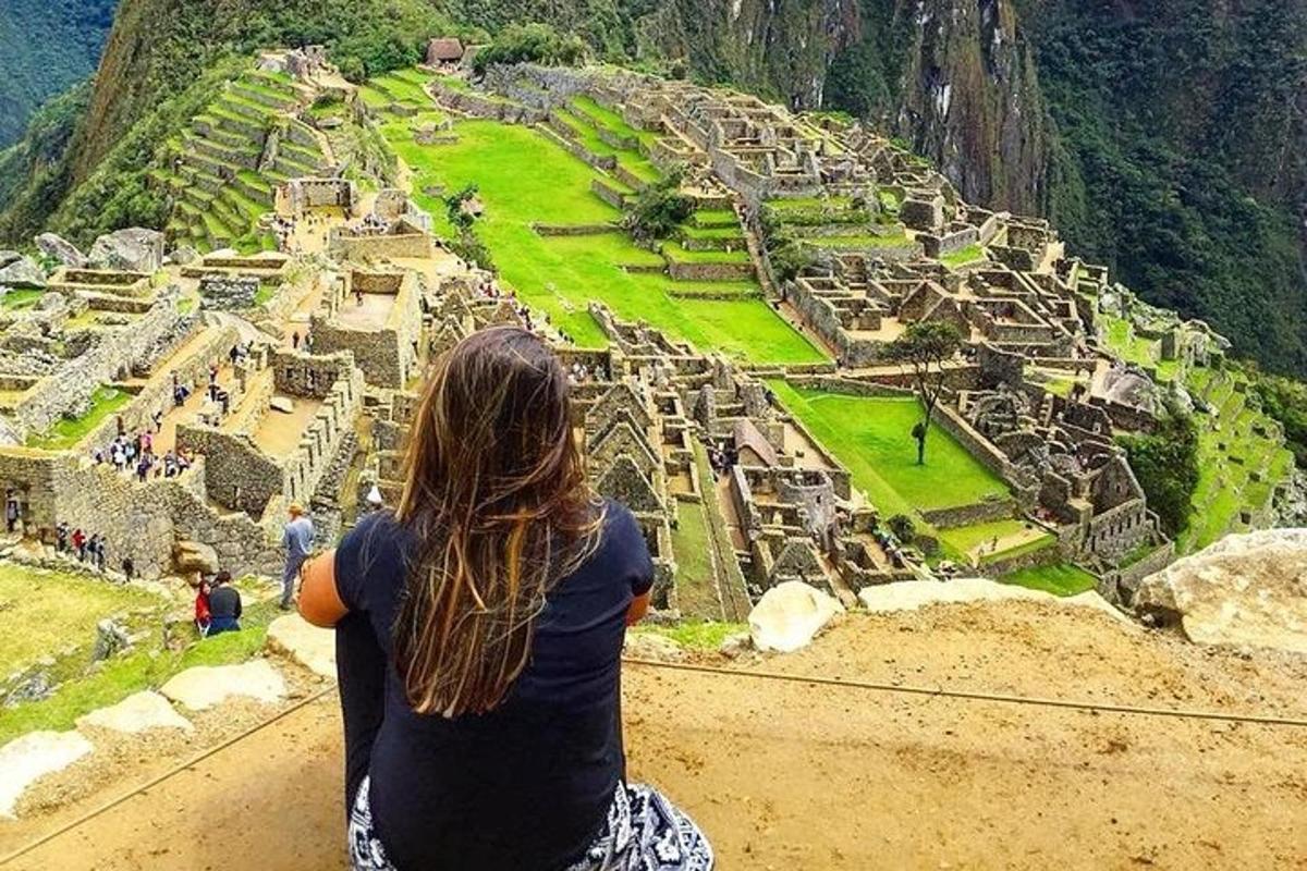 một người phụ nữ ngồi trên vách đá nhìn xuống đống đổ nát