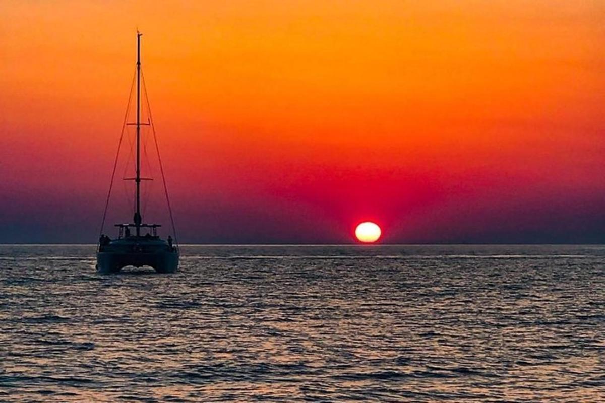 una barca nell'oceano con un tramonto