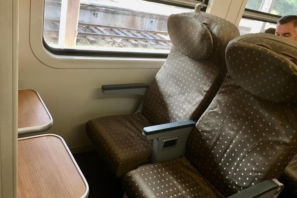 un posto su un treno con un uomo che guarda fuori dal finestrino