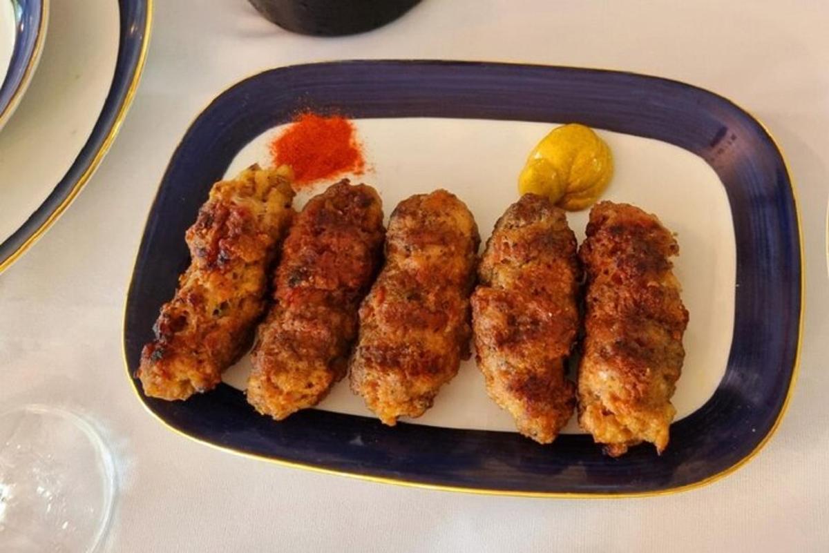 a plate of food with chicken skewers and a lemon