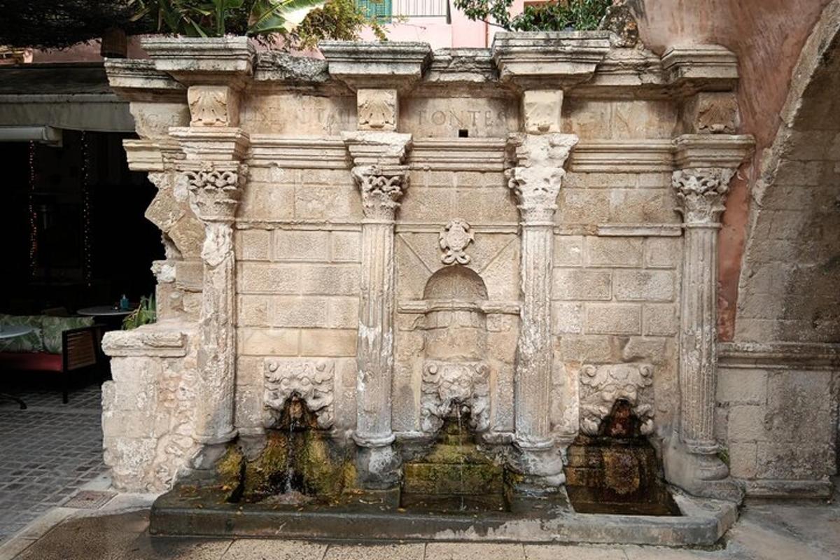 un edifici de pedra amb una font al pati