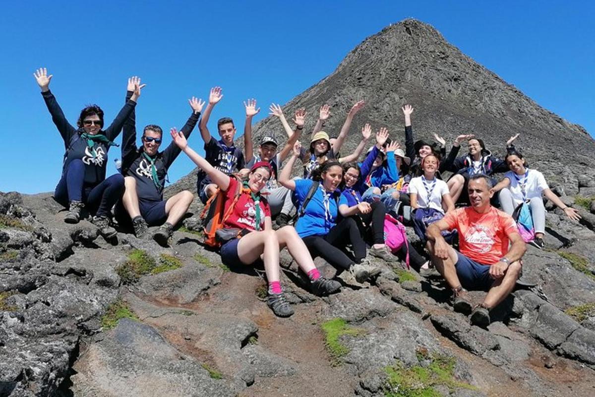 a group of people posing for a picture on a mountain