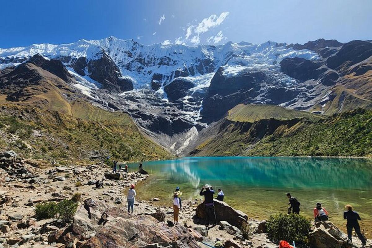 un gruppo di persone in piedi sulle rocce vicino a un lago di montagna