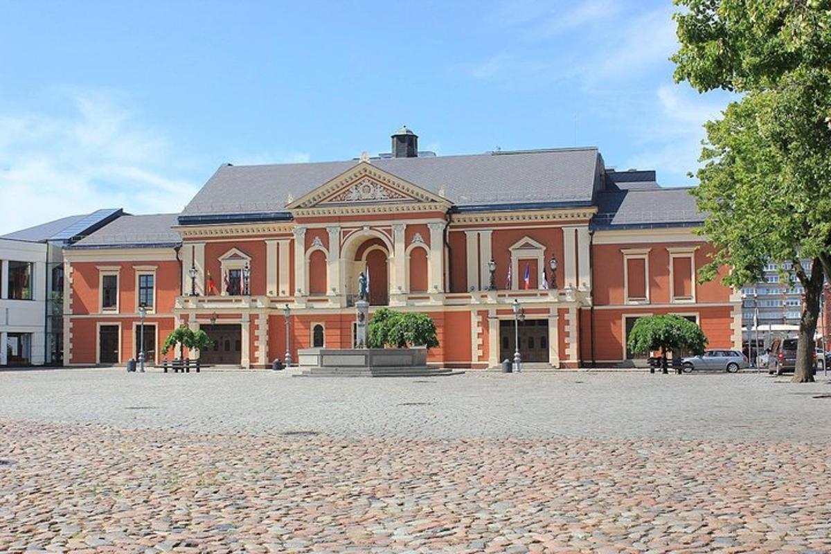 a large brick building with a statue in front of it