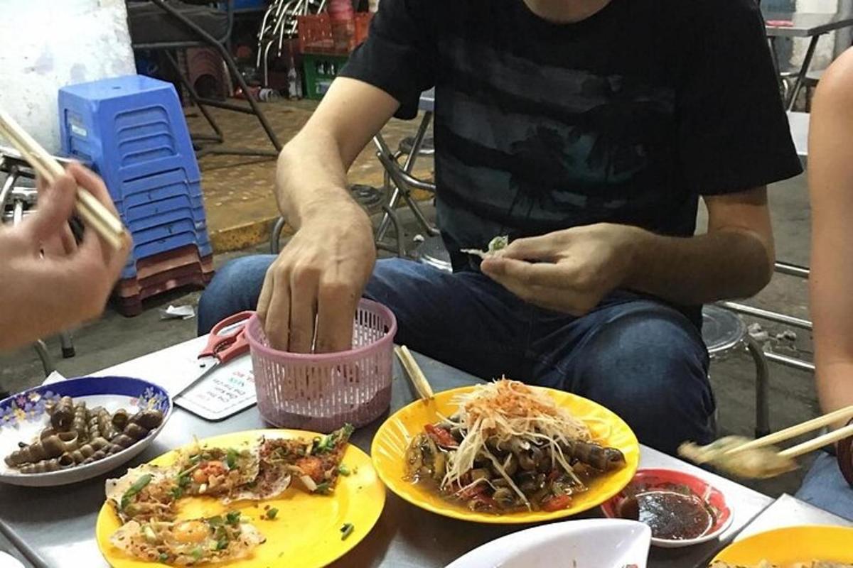 vyras, sėdintis prie stalo su lėkštėmis maisto