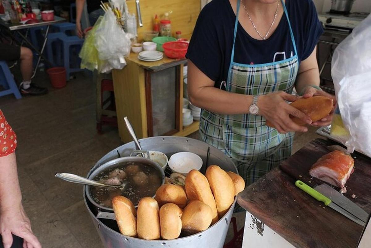 moteris virtuvėje su puodu maisto