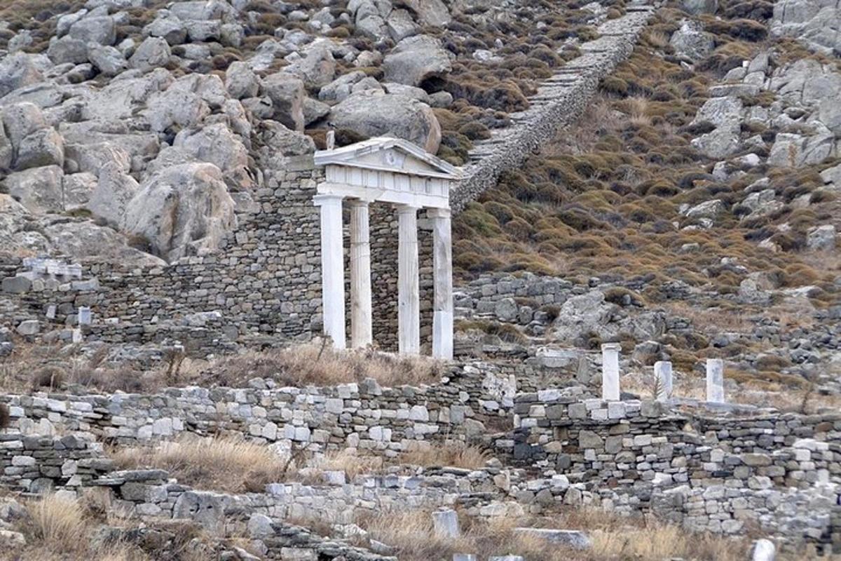 un edificio en una ladera rocosa con un muro de piedra
