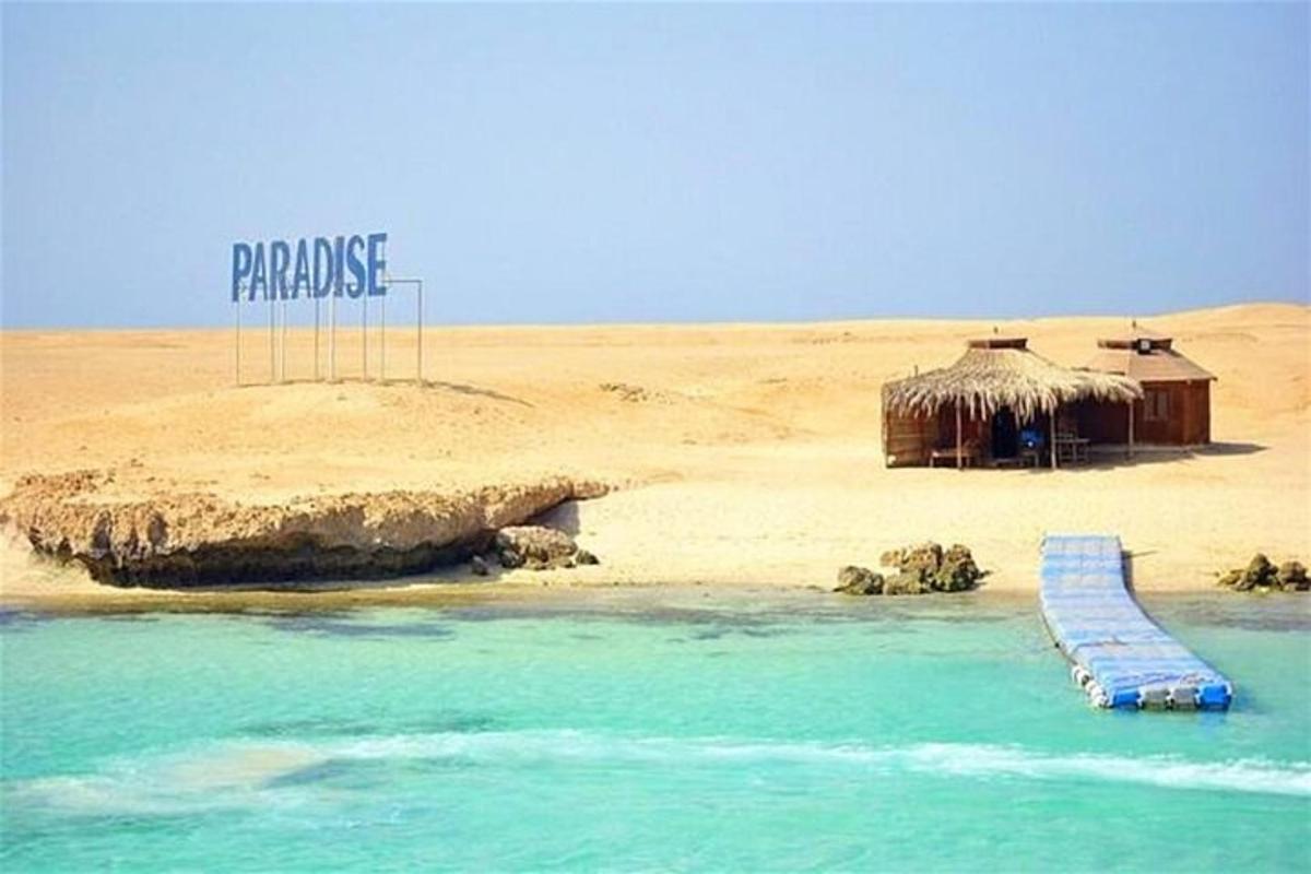 uma praia com cabanas e as palavras paraíso