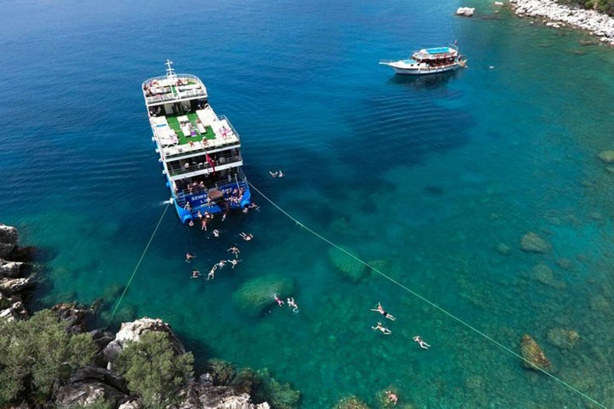 persone che nuotano nell'acqua accanto a una barca in acqua