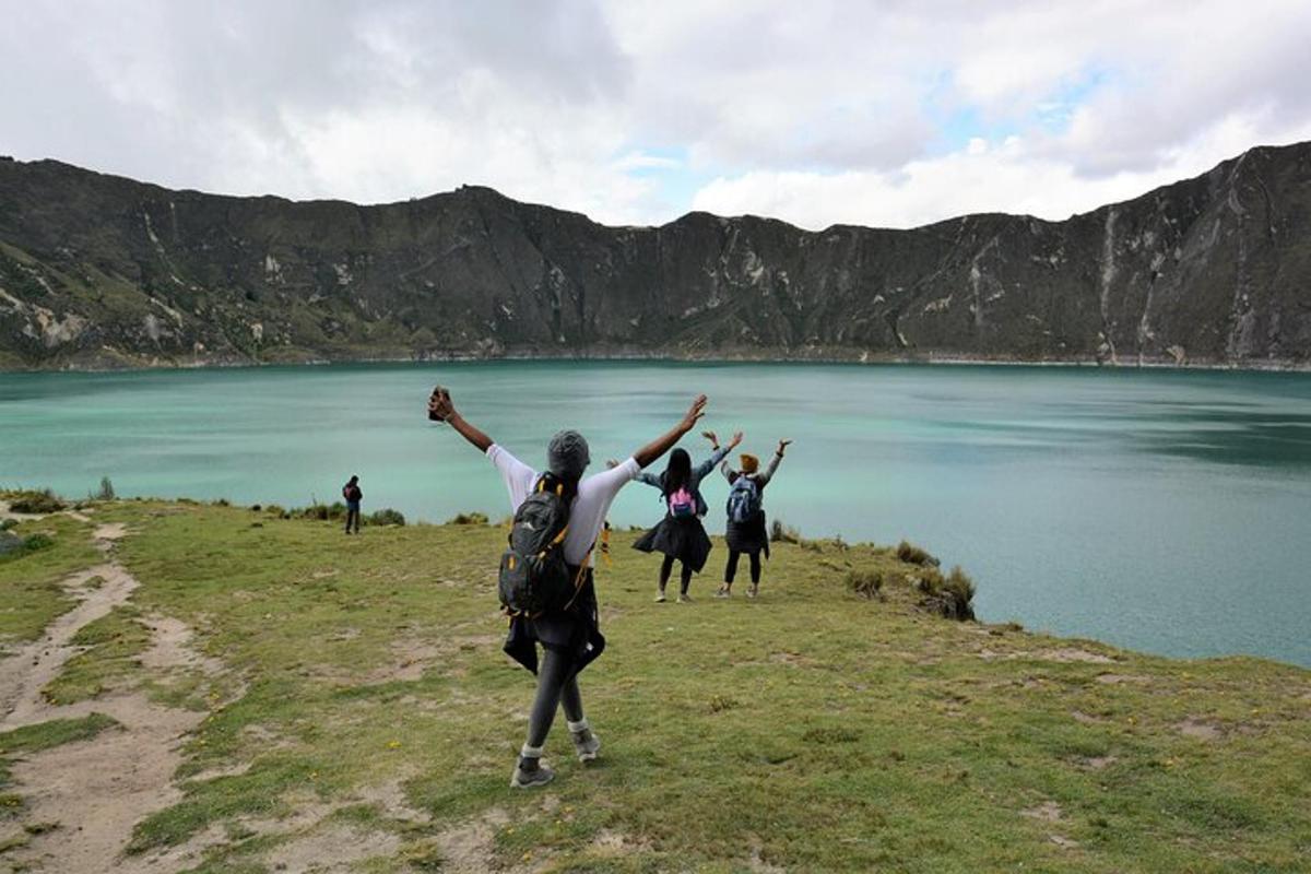 a group of people standing on a hill near a body of water