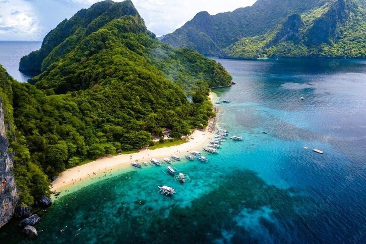 an aerial view of a beach with boats in the water