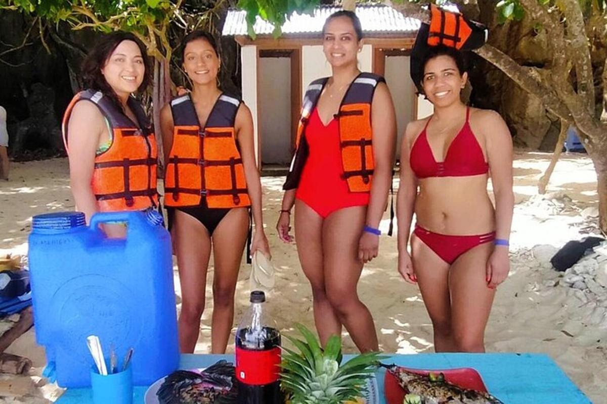 three women in swim suits standing on the beach