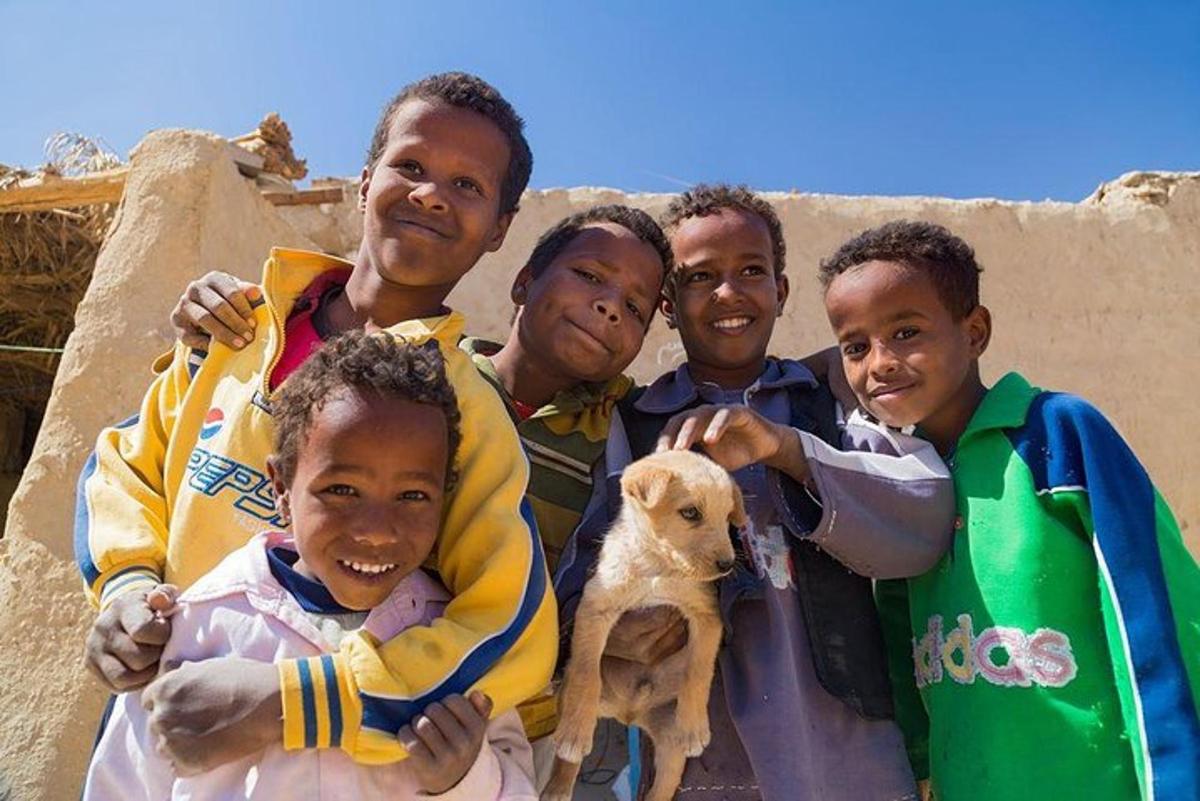un gruppo di bambini in posa per una foto con un cucciolo