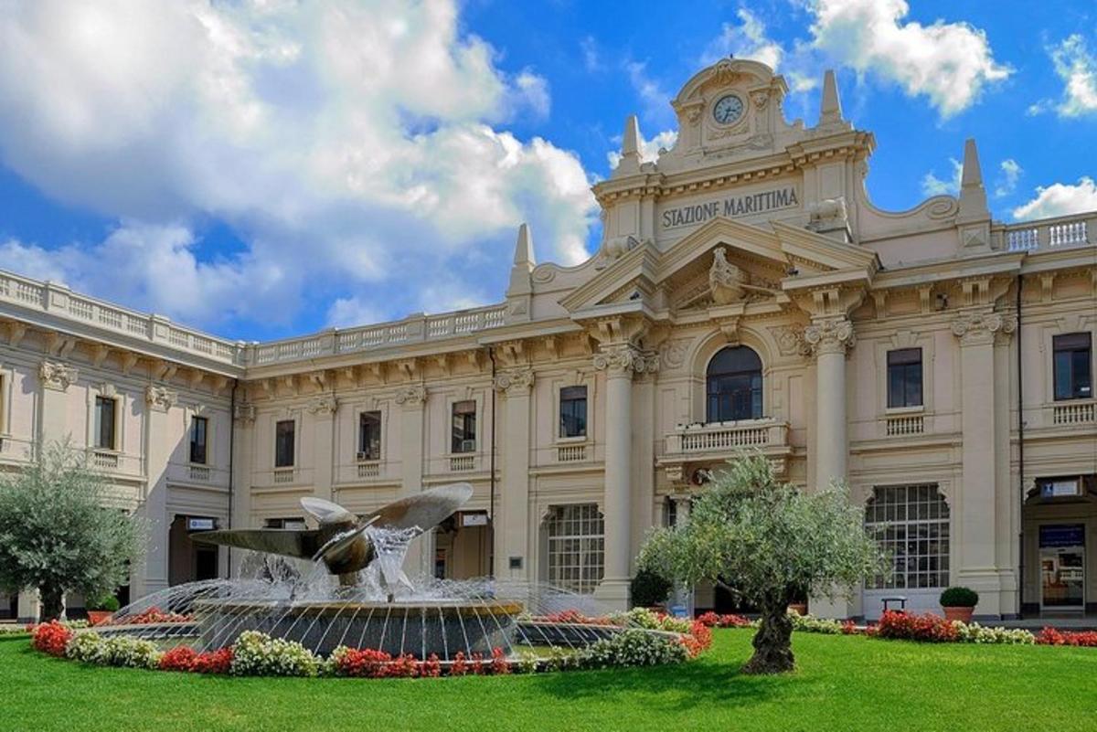 Un gran edificio con una fuente delante.